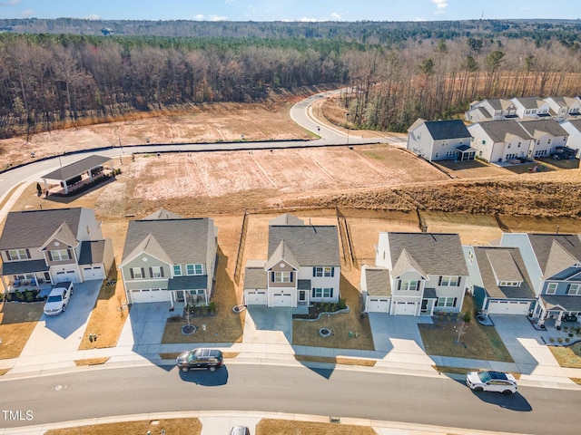 drone / aerial view featuring a residential view and a forest view