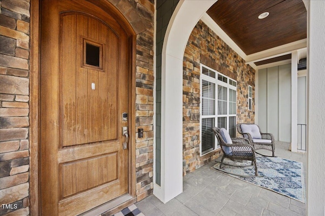 doorway to property with covered porch and brick siding