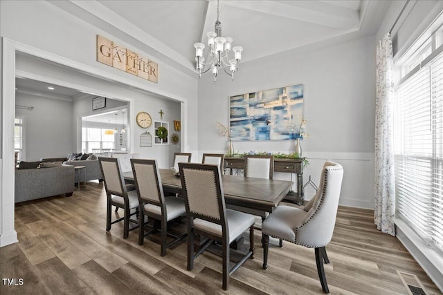 dining space featuring a wainscoted wall, visible vents, an inviting chandelier, and wood finished floors