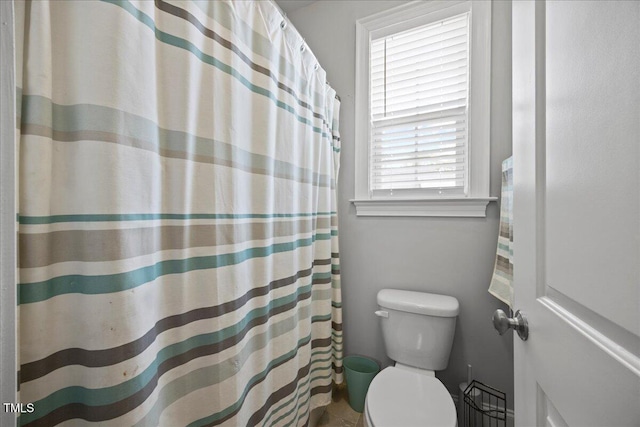 full bathroom featuring a shower with shower curtain and toilet