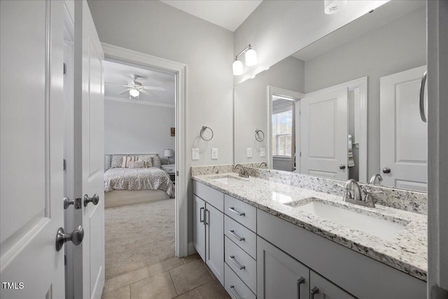 ensuite bathroom featuring a ceiling fan, tile patterned flooring, a sink, and double vanity