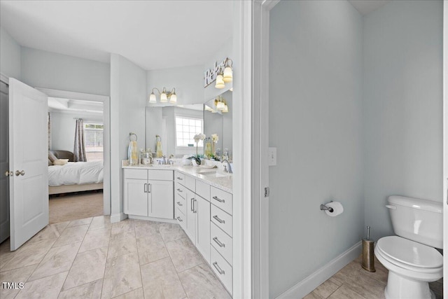 full bathroom featuring a sink, ensuite bath, toilet, and double vanity