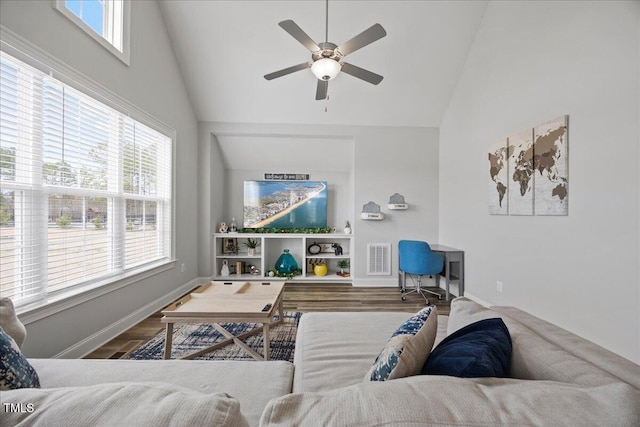 living area featuring a wealth of natural light, visible vents, and wood finished floors