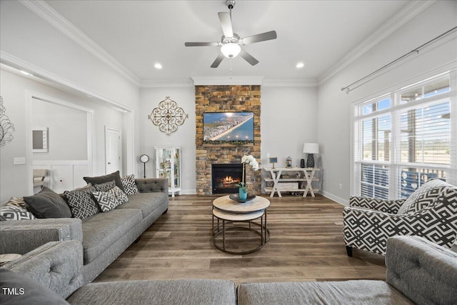 living room with a stone fireplace, recessed lighting, wood finished floors, a ceiling fan, and crown molding