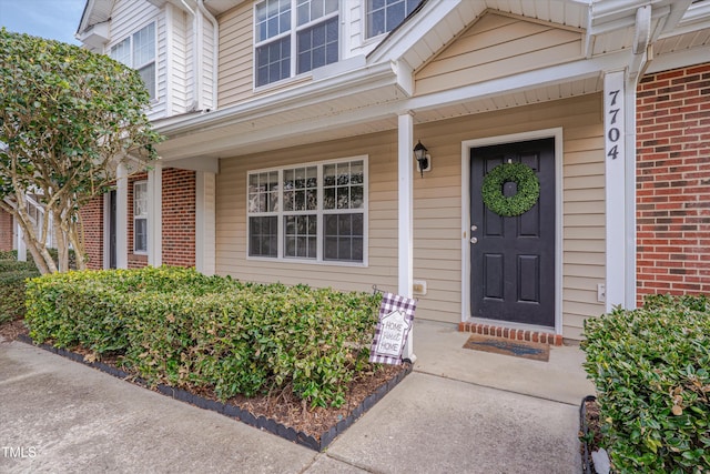 view of exterior entry featuring brick siding