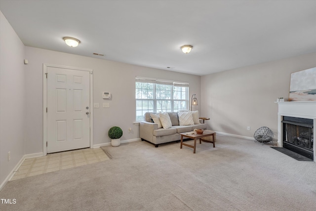 carpeted living room with a fireplace with flush hearth, visible vents, and baseboards