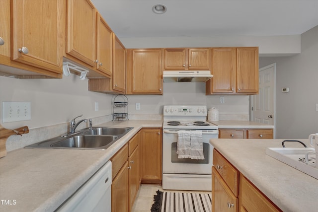 kitchen featuring white appliances, light countertops, a sink, and under cabinet range hood