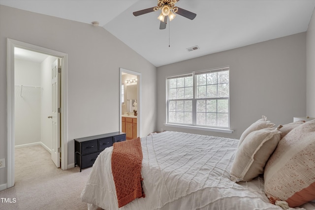 bedroom with a walk in closet, lofted ceiling, light colored carpet, visible vents, and ceiling fan