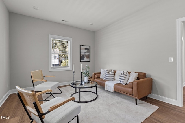 living area featuring wood finished floors, visible vents, and baseboards