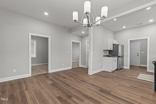 unfurnished living room with baseboards, dark wood finished floors, and recessed lighting