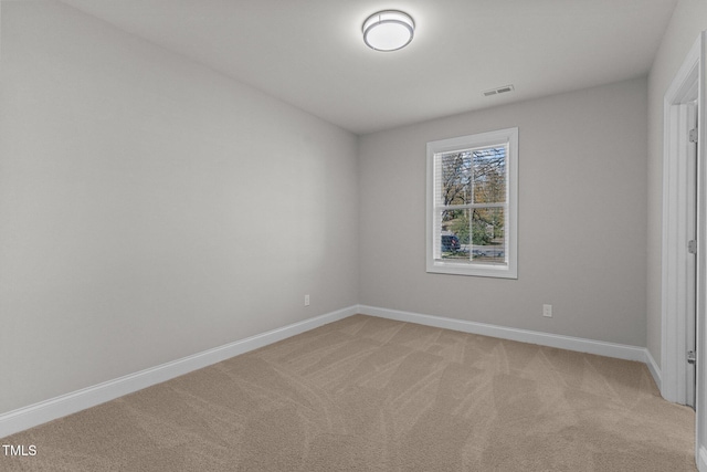 unfurnished room with light colored carpet, visible vents, and baseboards