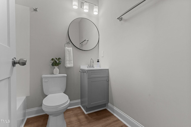 bathroom featuring vanity, wood finished floors, toilet, and baseboards