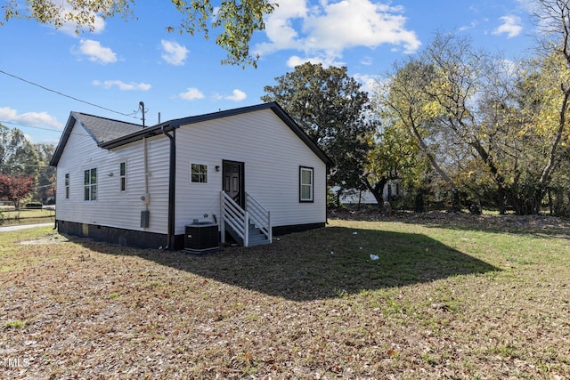 back of house featuring cooling unit, a lawn, and entry steps