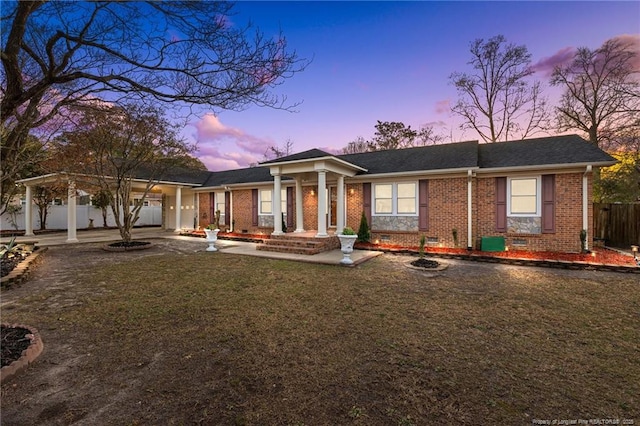 view of front of property featuring brick siding, a shingled roof, a front yard, crawl space, and fence