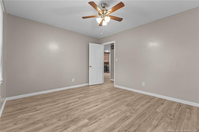 empty room with light wood-type flooring, ceiling fan, and baseboards