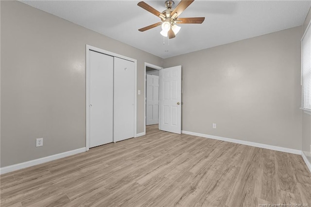 unfurnished bedroom featuring baseboards, a closet, a ceiling fan, and light wood-style floors