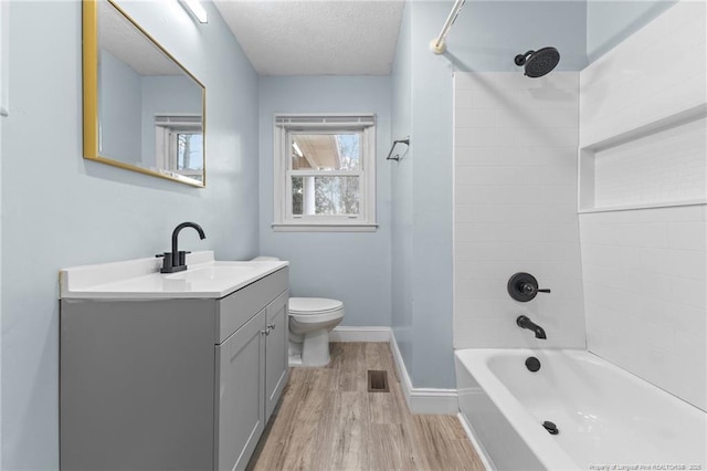 bathroom featuring visible vents, toilet, a textured ceiling, wood finished floors, and baseboards