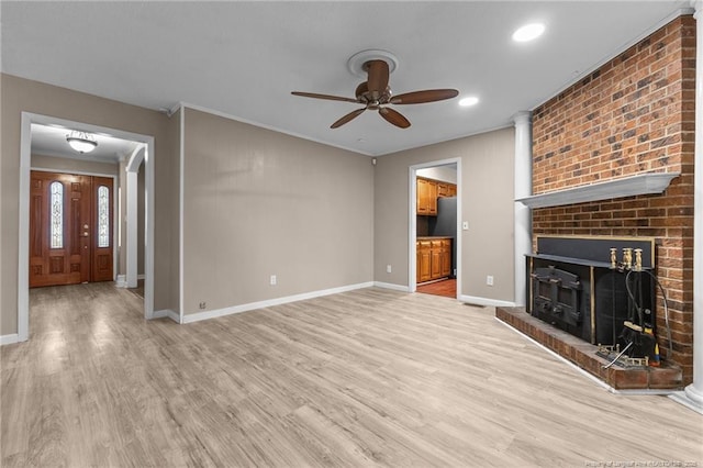 unfurnished living room with light wood-type flooring, a fireplace, and baseboards