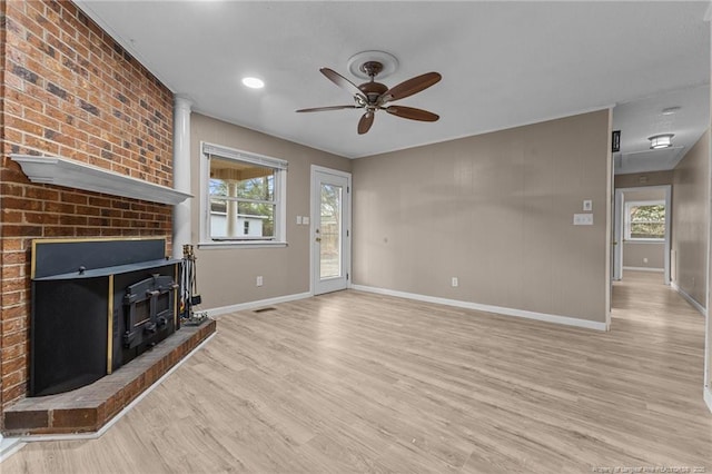 unfurnished living room with a healthy amount of sunlight, light wood-style floors, baseboards, and a ceiling fan