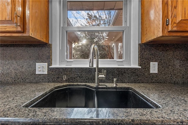 kitchen with tasteful backsplash, brown cabinets, and a sink
