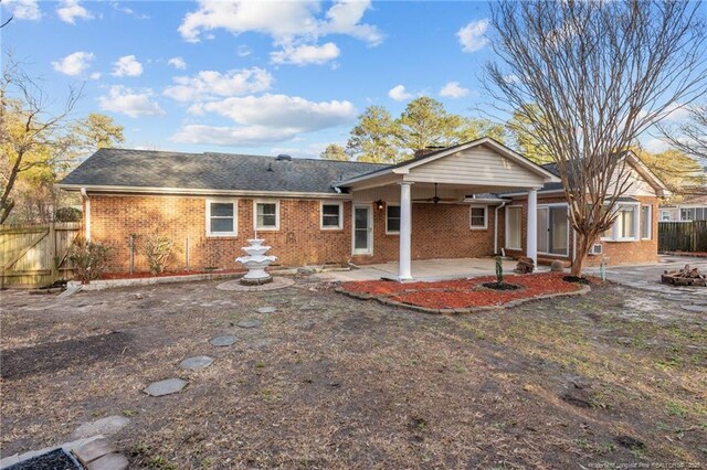 back of property featuring brick siding, fence, a ceiling fan, and a patio