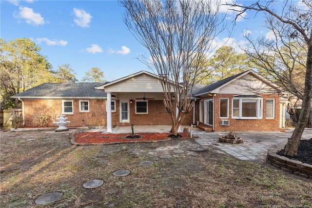 ranch-style home with a patio area, a fire pit, a ceiling fan, and brick siding