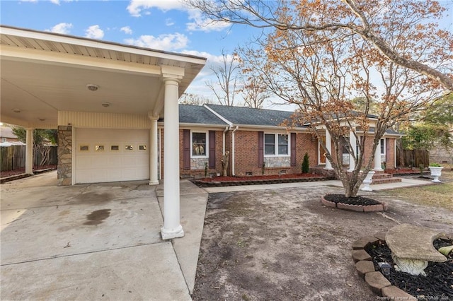 view of front facade with brick siding, a shingled roof, concrete driveway, fence, and an attached carport