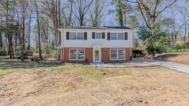 view of front facade featuring brick siding and a front yard