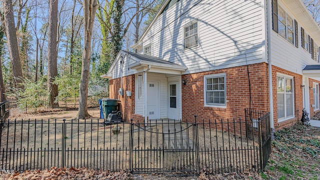 view of front of property featuring brick siding and a fenced front yard