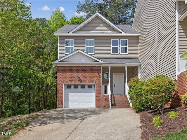 traditional home featuring an attached garage, driveway, and brick siding