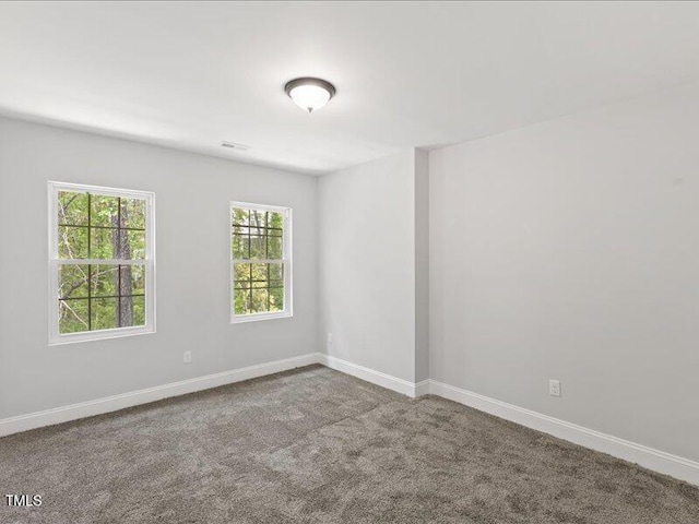 unfurnished room featuring baseboards, visible vents, and carpet floors