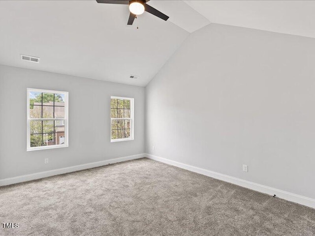 empty room featuring a ceiling fan, lofted ceiling, visible vents, and carpet floors
