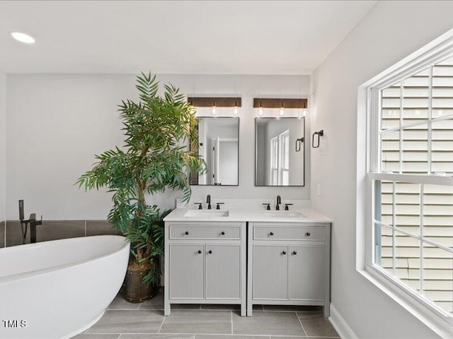 full bath with double vanity, a sink, and a soaking tub