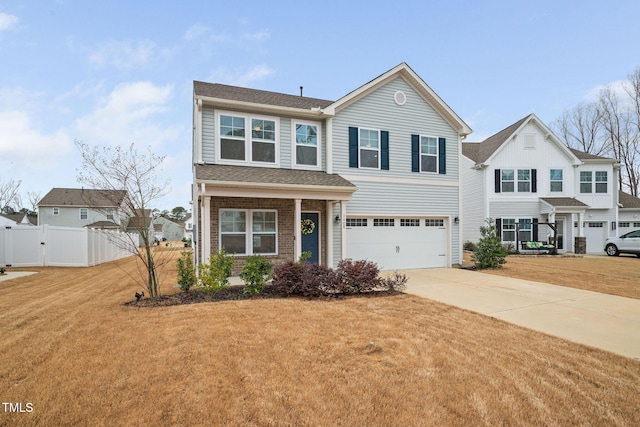 traditional-style home featuring an attached garage, brick siding, fence, concrete driveway, and a front yard