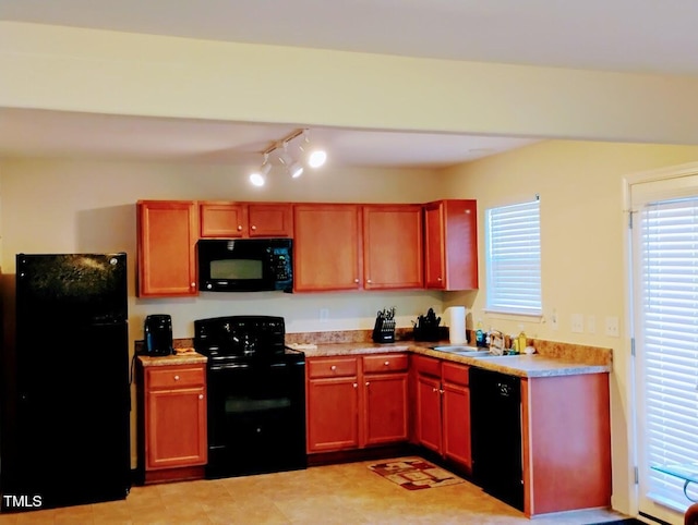 kitchen featuring black appliances, light countertops, and a sink