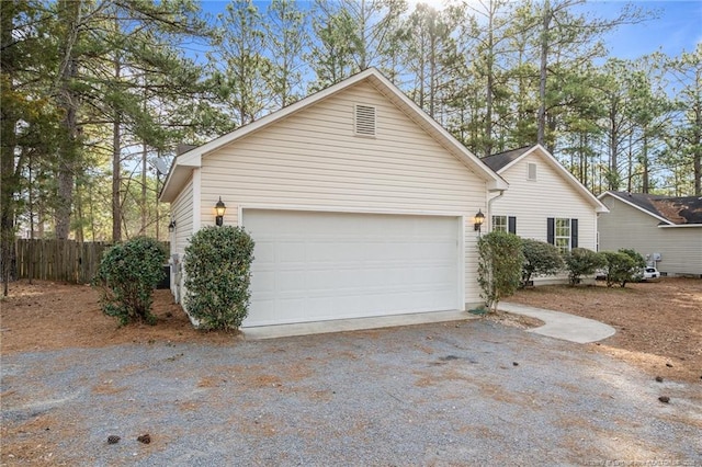 view of side of home featuring a garage and fence