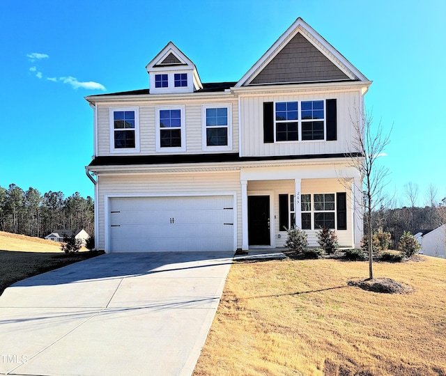 view of front of property with covered porch, board and batten siding, a garage, driveway, and a front lawn