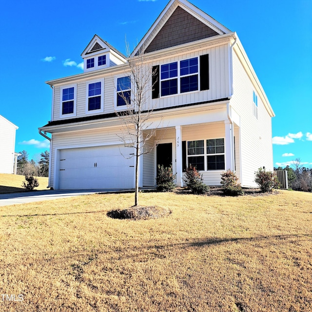 view of front of property featuring board and batten siding, a front yard, driveway, and a garage