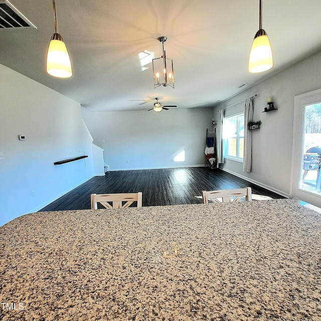 kitchen featuring pendant lighting, dark wood-style flooring, visible vents, a ceiling fan, and baseboards