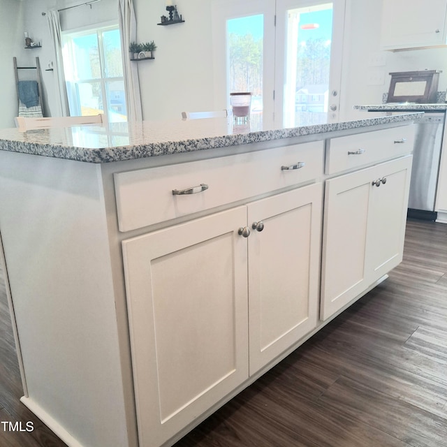 kitchen featuring dark wood-type flooring, light stone countertops, and white cabinets