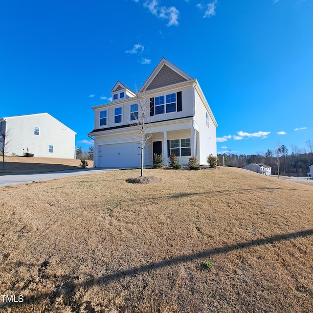 view of front facade with driveway, a front lawn, and an attached garage