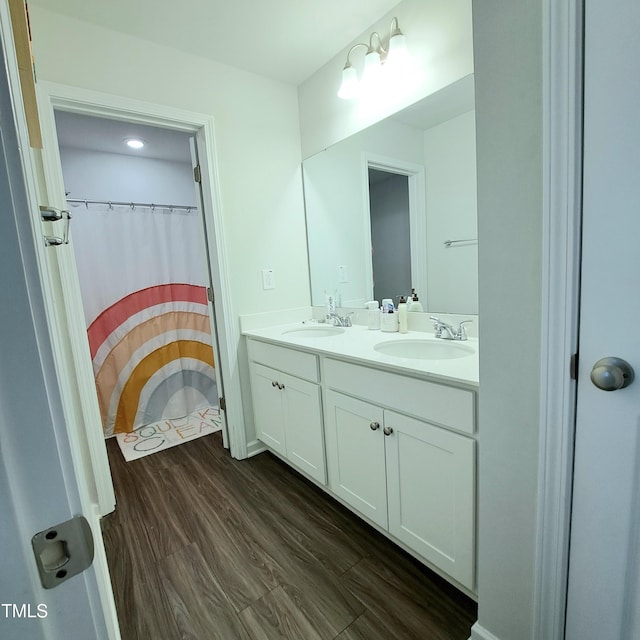 bathroom featuring double vanity, a sink, and wood finished floors