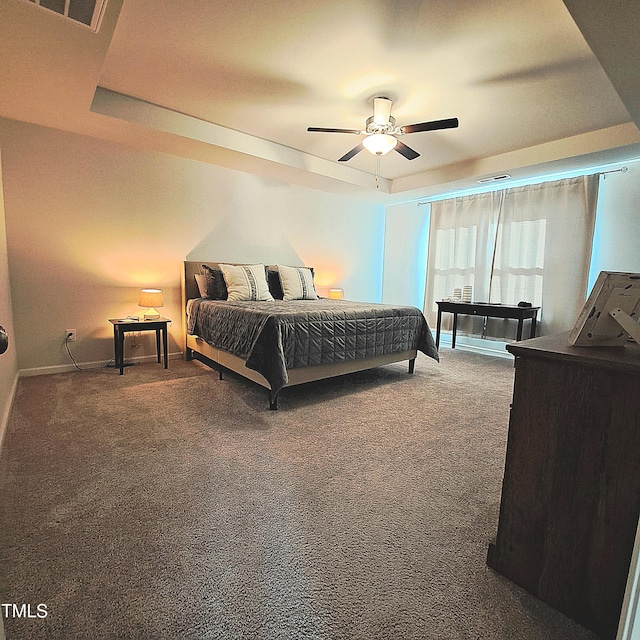 bedroom featuring a tray ceiling, visible vents, and carpet