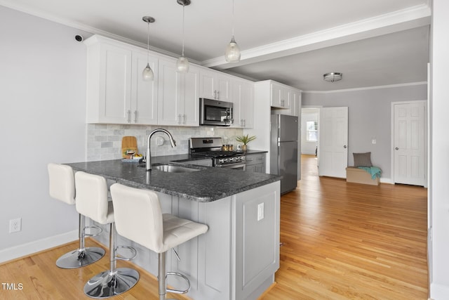 kitchen with backsplash, crown molding, stainless steel appliances, and a sink