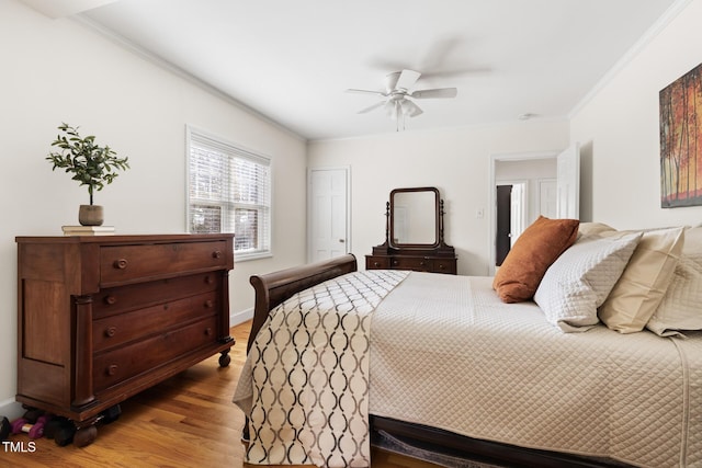 bedroom featuring ceiling fan, wood finished floors, and crown molding