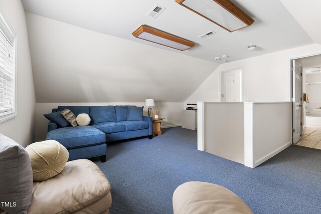 carpeted living room with lofted ceiling, baseboards, and visible vents