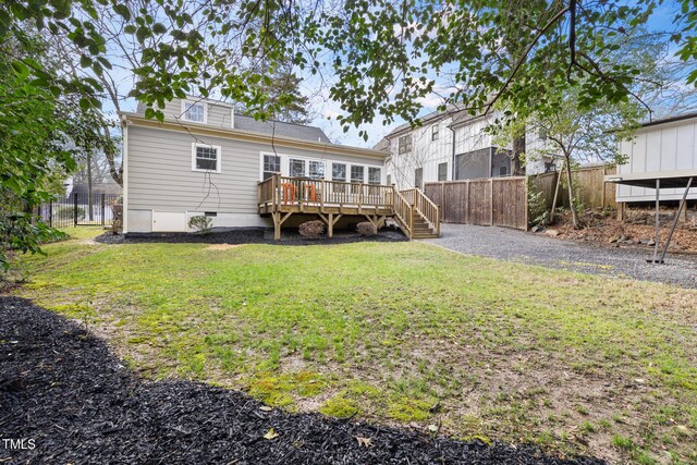 back of property featuring crawl space, fence, a wooden deck, and a lawn