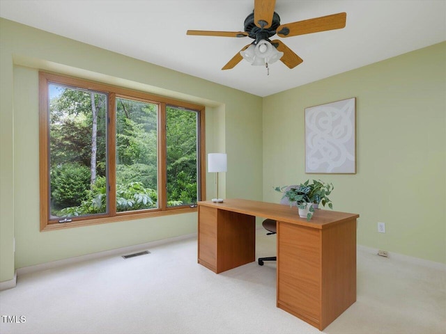 office space with light carpet, baseboards, and ceiling fan