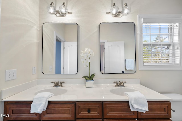 bathroom featuring a sink, toilet, and double vanity