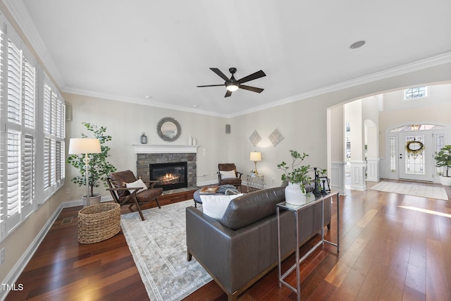 living room with ornamental molding, arched walkways, and hardwood / wood-style floors